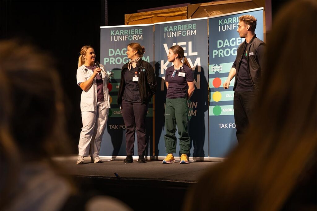 Tre sygeplejersker præsenterer sig selv på scenen